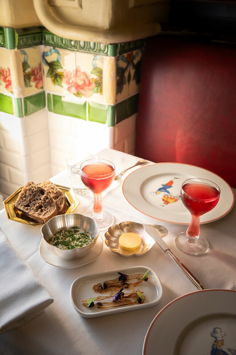 サヴォワ地方の上質なロゼのスパークリングワイン（グラス）7ユーロ。脚まで液体が入るグラスはデュカス氏が蒐集したベル・エポックのもの。突き出しの豚の耳のクルスティヤン、フレッシュチーズのディップソースなどとともに。