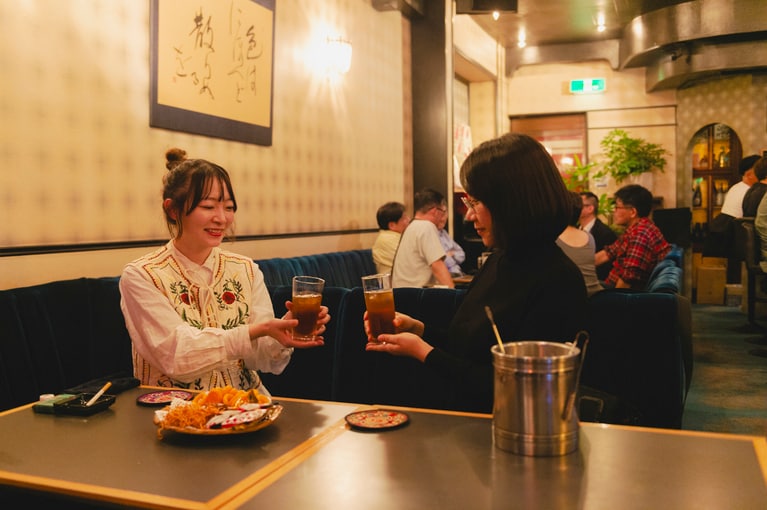 歌人であり文筆家の上坂あゆ美さんは、実は大のスナック好き。佐渡市相川下戸町にある「スナックJ１」にて乾杯。店内には街の人たちが集まり、楽しいトークが飛び交いぎわっていました。