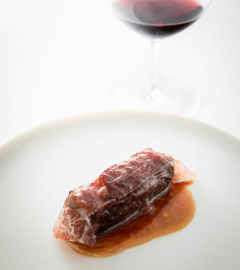 スペインのガリス牛を焼き、スペイン産セシーナ（熟成生ハム）を巻きつける。オリーブオイルで焼いて出る肉汁だけで勝負する、潔い一皿。