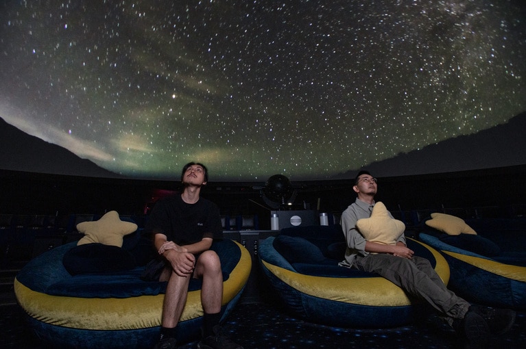 ゆったりと浸れる「三日月シート」。プラネタリウムの映像は今回の作品とは関係ありません。