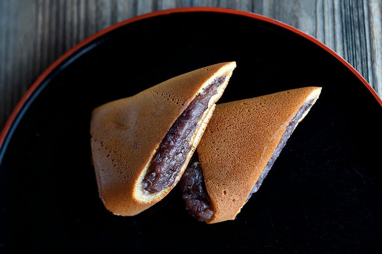 【大塚屋】まであんこがたっぷりの三角どらやき(205円、2個入)。店内にはセルフサービスのお茶もあり、その場で食べることもできます。