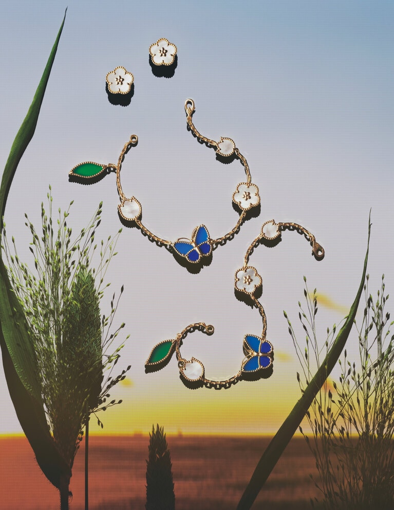 ≪上≫「ラッキー スプリング イヤリング、プラムブロッサム」（YG×ホワイトMOP）852,500円、≪中・下≫「ラッキー スプリング パピヨン ブレスレット、5モチーフ」（YG×ラピスラズリ×ブルー＆グリーンアゲート×ホワイトMOP）各1,082,400円／ヴァン クリーフ＆アーペル（ヴァン クリーフ＆アーペル ル デスク）