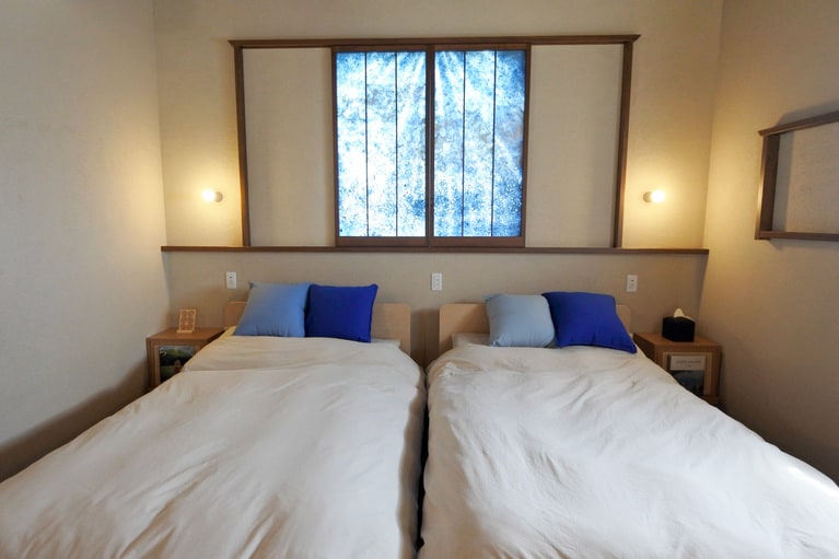 一段上がったベッドルーム。ジェイコブス・ラダーのような美濃手漉き和紙の作品が壁に。