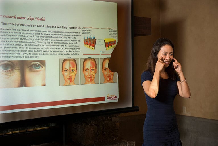 アーモンドを食べたグループの肌の変化を説明するミュリエルさん。