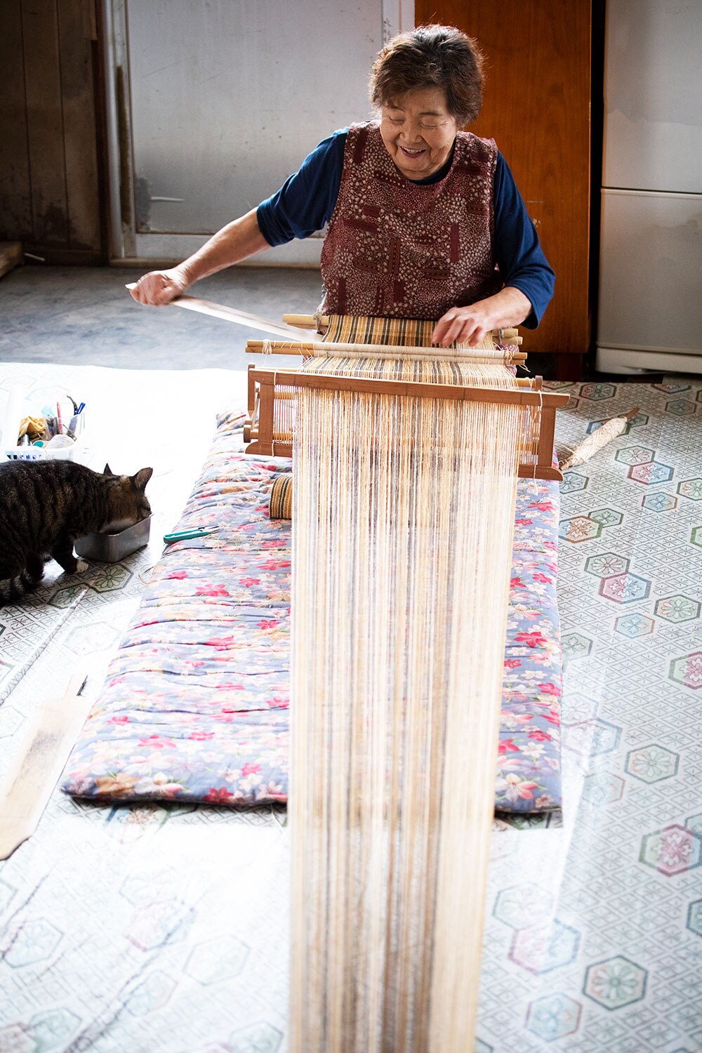子どものころからアットゥシ織りに関わり続け、「糸に触れているときがいちばん楽しい」と語る貝澤雪子さん。機織りをするそばには愛猫のハナちゃんが。先日は貴重な伝統文化の継承に貢献した人物に贈られる「伝統文化ポーラ賞」を受賞した。