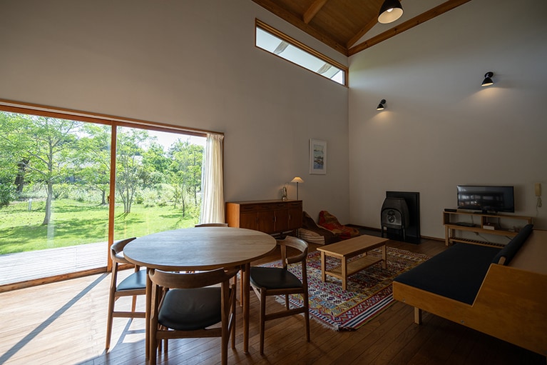 スーペリア・スイート。薪ストーブのある2階建ての一軒家。メゾネットタイプの部屋になっており、2階のベッドルームからは久美浜湾が一望できる。