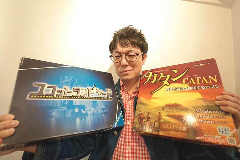 お気に入りのボードゲームを手にした佐藤さん。ゲームプレイ中はかなり口が悪いそうです(笑)。