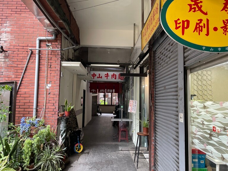 入り口の左側に通路があり、その先に進むとお目当ての牛肉麺屋の大きな看板が見えてきます。