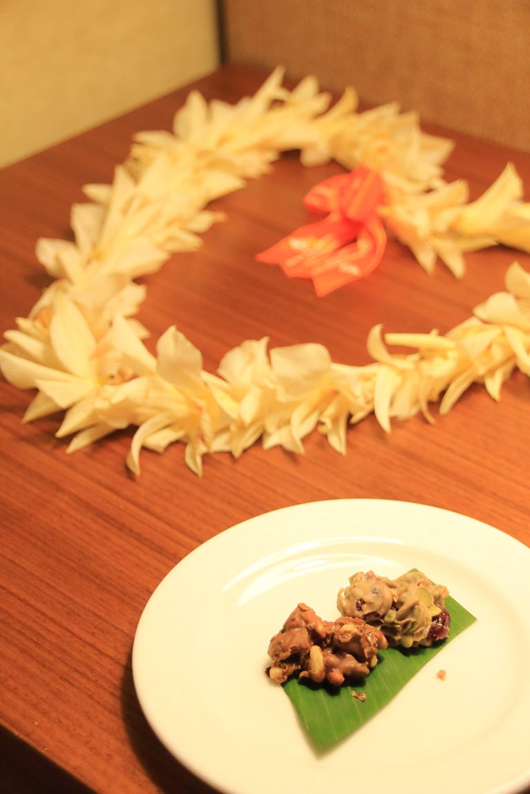 ターンダウンサービスの際に置かれるチョコレートの脇に、チェックイン時に首にかけてくれたレイがハート型に置かれていた。かわいい！