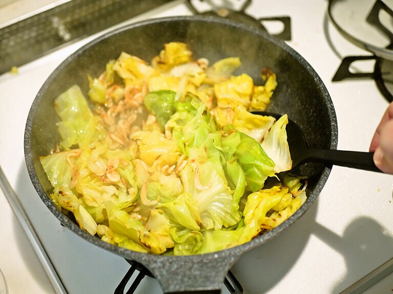 4分経ったらフタを開けて、塩を入れて全体をよく和えます。さあ、もう完成。盛りつけていきましょう。