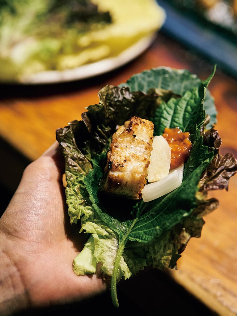 サンチュ、エゴマの葉、白菜、ケール、青唐辛子は食べ放題。サムジャン（味噌ダレ）か特製のシナモン風味のタレをつけて。