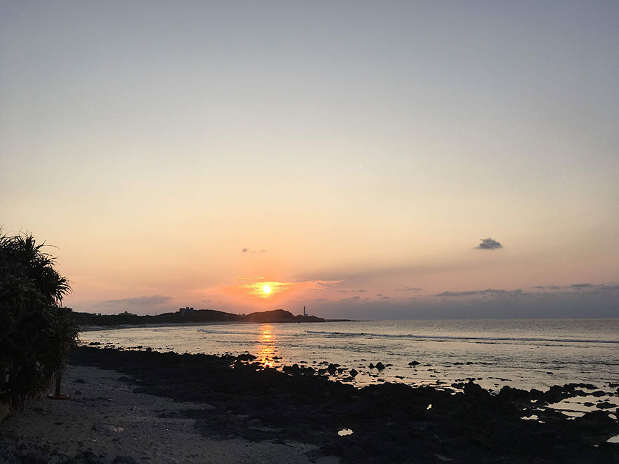 灯台の脇に沈んでいく夕日。