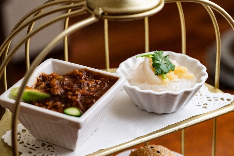 鳥籠の一段目は、ひき肉とアスパラガスの麻婆あんかけ（左）、帆立と春雨のにんにく蒸し（右）。