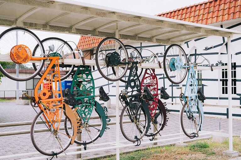 宇野駅のすぐそばにある作品「終点の先へ／小沢敦志作」。鉄の廃材をぺちゃんこに叩き、放置自転車に溶接してレンタサイクルに再生させた。