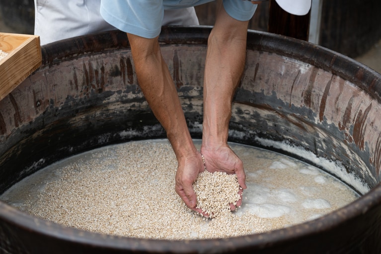 仕上げに、液面に浮かせるように米麹をそっと振り入れる。