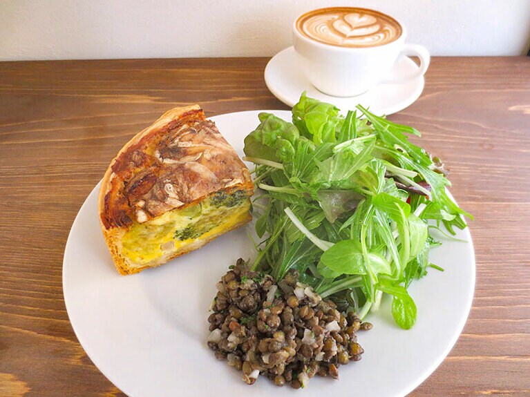 ランチ「本日のキッシュ、サラダ付き」1,200円。「カフェラテ」570円。「コーヒー」490円。ナチュラルワインは660円～。金・土曜17時～のディナータイムは「ウフマヨ」330円や「レンズ豆のサラダ」400円などあり。