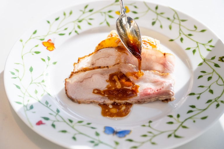 メイン料理「ビゴール豚ロースの低温3時間ロースト“スペシャリテ” 軽やかなジュと共に ドフィノワポテトとグリュイエールチーズのグラタン」。