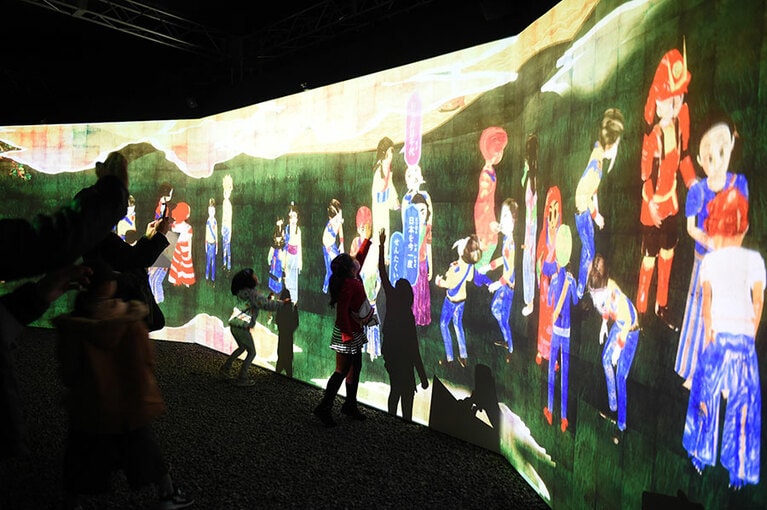 スクリーンに現れる、高知県にゆかりのある歴史上の人物やピープルにタッチして遊ぶ子供たち。