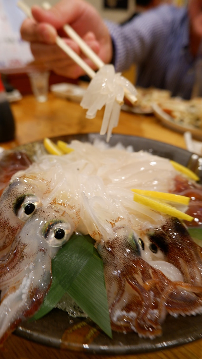 豪勢に盛り付けられたイカ刺しをお箸で「ぶわっ」とすくう幸せの瞬間。