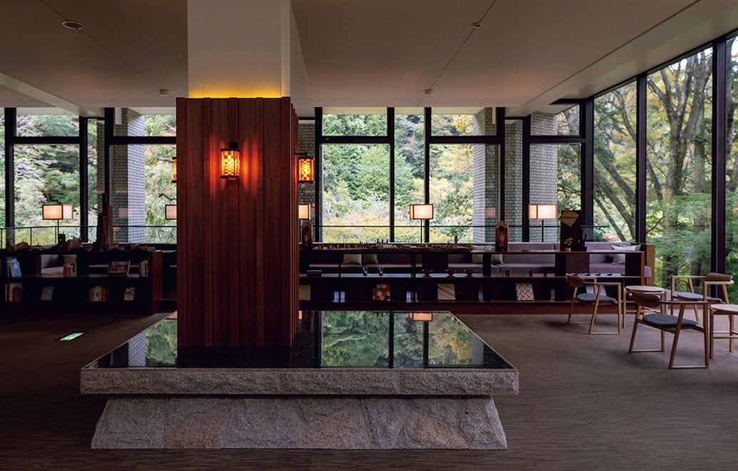 山懐に抱かれたフロントロビー。御影石のベンチにも山が映る。