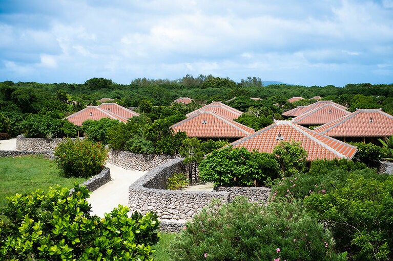 赤瓦屋根の客室、白砂の小路、客室を取り囲む石垣などが見渡せる。