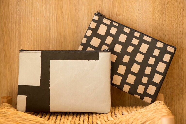 SIWAのポーチ 各3,300円。紙なのに中性洗剤で洗えるところがすごい！　写真は染色家・柚木沙弥郎の書き下ろしデザイン。