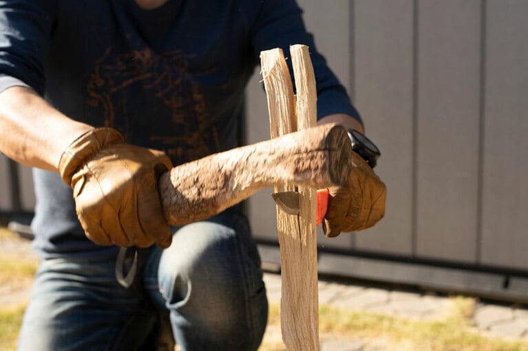 ナイフの刃の背付近を木材でたたくのがポイント。