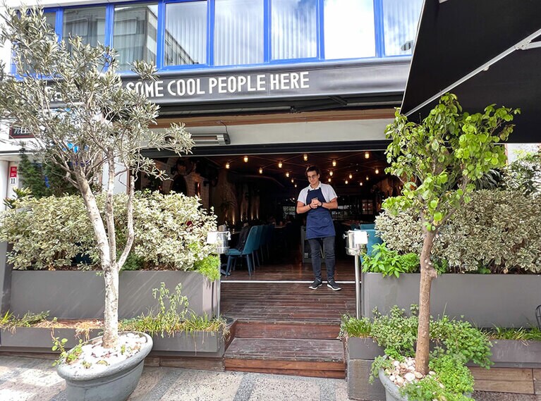 緑に囲まれたエントランス。小さなテラス席もある。