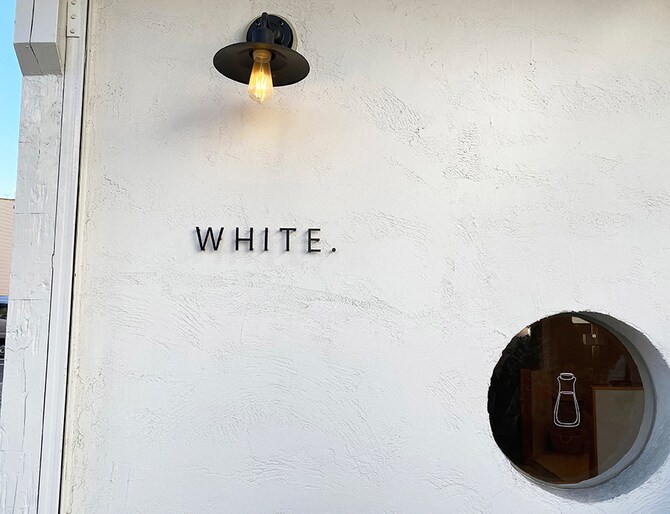 店名を照らす灯りやかわいい瓶が描かれた丸い窓に遊び心も感じられます。