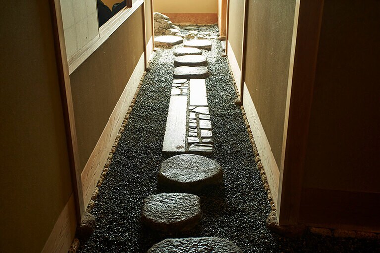 格子戸を開けると、そこは別世界。飛び石の置かれた道の先には、ふすまで仕切られた和室が。