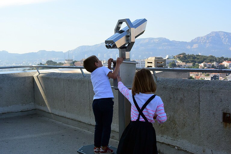 聖堂の見晴らし台からは石灰岩の岩山や島々が浮かぶ地中海の眺めが広がります。望遠鏡をめぐって覇権争い？