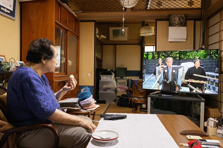 おやつを食べながら、大好きな「必殺仕置人」を観る堀野さん。