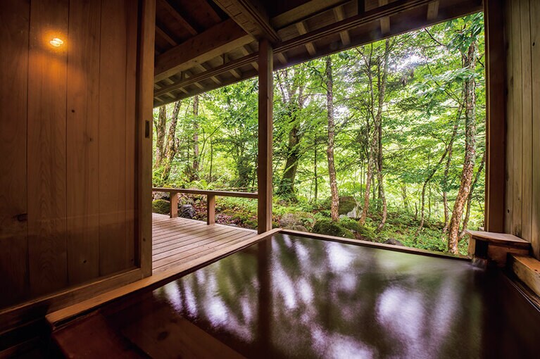 自家源泉「山の湯」を100％かけ流しで浴槽へ注いでいる客室露天風呂。泉質はナトリウム炭酸水素塩泉で、共同の露天風呂もある。