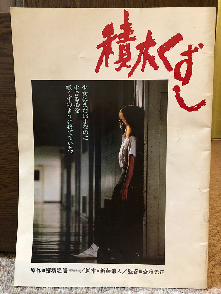 映画版『積木くずし』のパンフレット(私物)。ドラマ版の高部知子さんの降板で渡辺典子さんが抜擢。散々な前評判に正面から頭突きをかますような迫真の演技で、私も映画館で「怖ッ……」とフリーズしたのを覚えている。