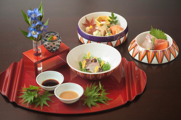 毬のような形をした三段重の器を開いていくと、八寸やお造りが現れるサプライズな仕掛けも。「サントリー塩尻ワイナリー」のメルローのロゼとともに。