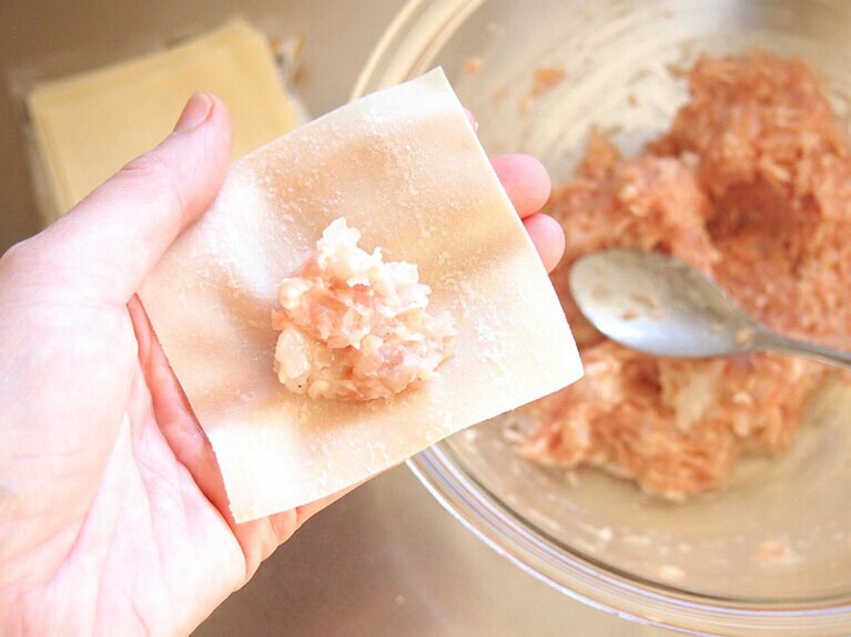 (3) 出来上がったタネを、ワンタンの皮で包みます。