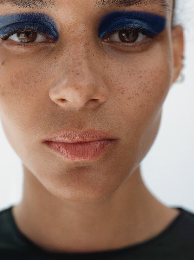 ゾエ・ガートナーは湿度を感じるナチュラルな肌と唇で、ブルーの印象的な目元を際立たせた。