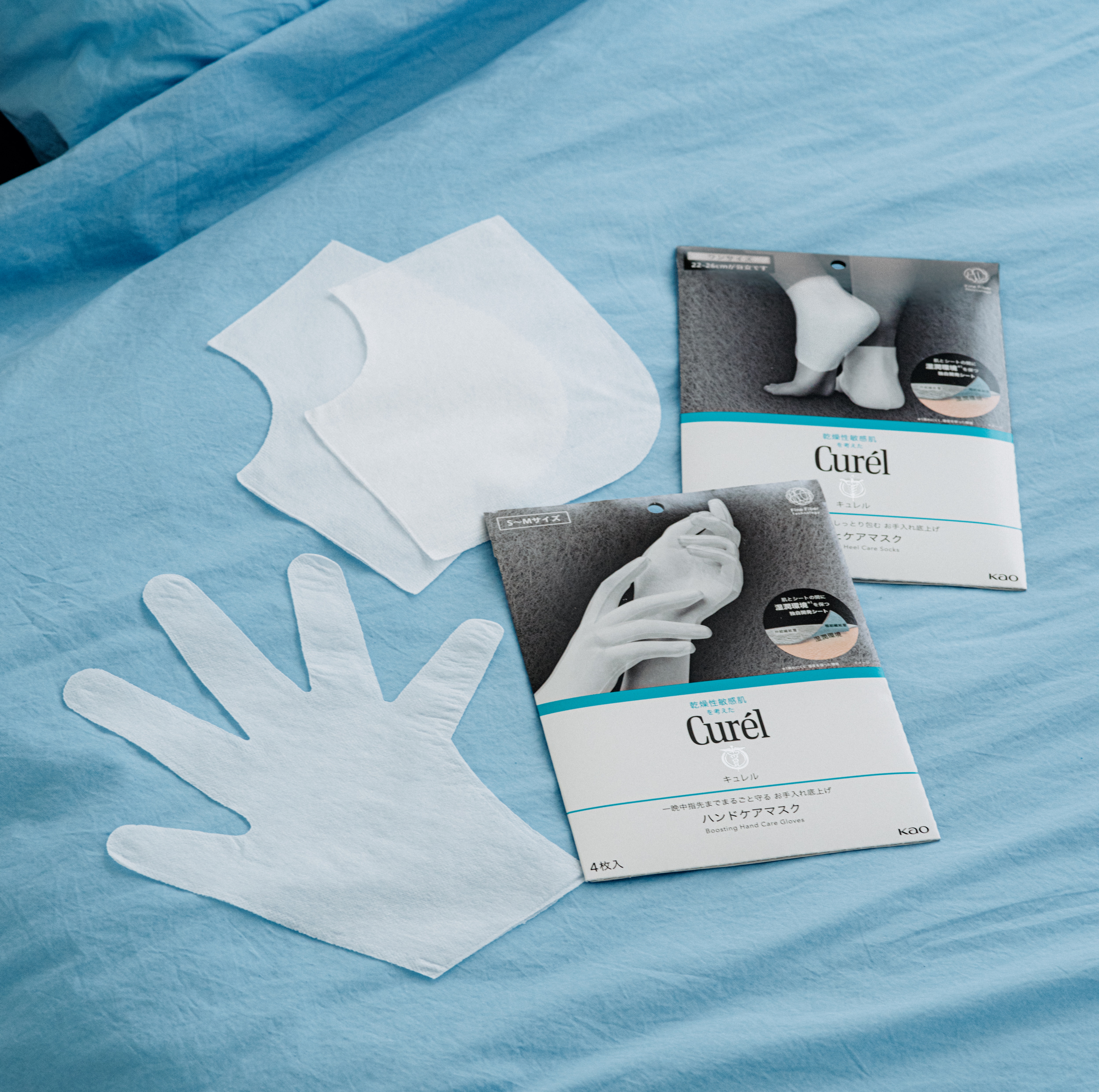 スキンケアしたあとにつけるだけで、なめらかにしっとり包み込み、お手入れを底上げ。蒸れにくく、素肌より乾きにくい特殊な二層構造で、肌とシートの間の“湿潤環境”※4を保ってくれる。手前から：キュレル 一晩中指先までまるごと守る お手入れ底上げ ハンドケアマスク 4枚入 全2種（M・L） 660円（編集部調べ）、キュレル ガサガサかかとをしっとり包む お手入れ底上げ かかとケアマスク 6枚入 550円（編集部調べ）