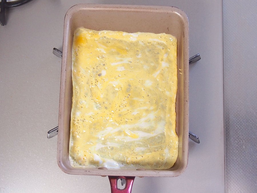 (3) 卵焼き用フライパンを温め、薄くサラダ油を塗ります。1/2量の溶き卵を入れて、全体に広げ、薄焼き卵にします。両面焼けたら取り出し、同じ要領で薄焼き卵をもう一枚焼きます。
