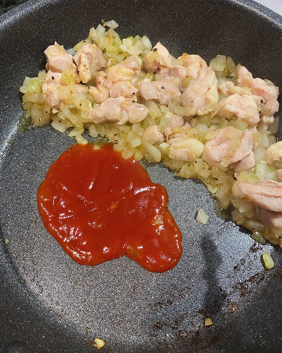 【焦がし醤油のケチャップライスが主役のオムライス】(3) 鶏肉に火が通ったら端に寄せ、ケチャップを加える。