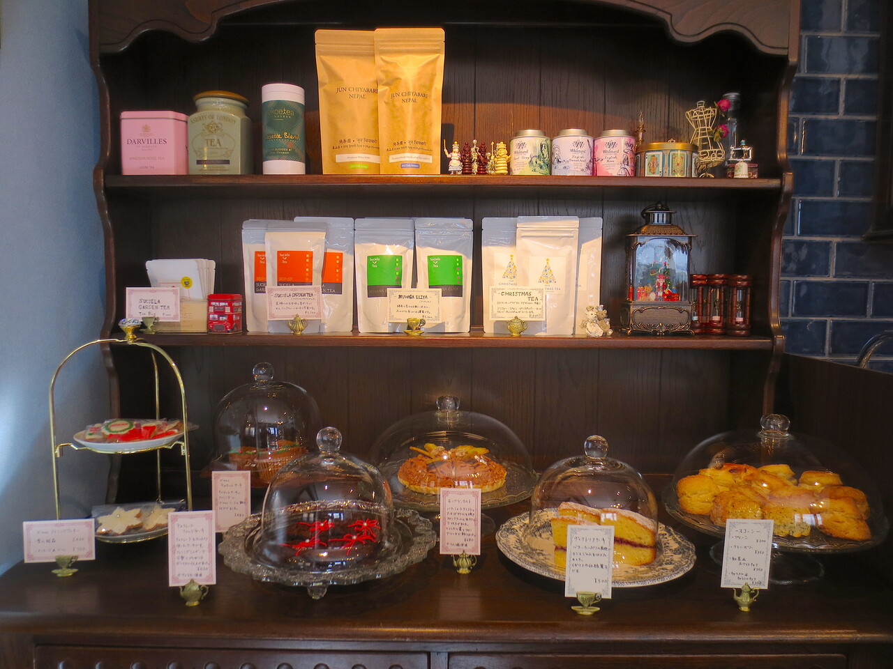 入って正面の食器棚に、スコーンやケーキが並んで。