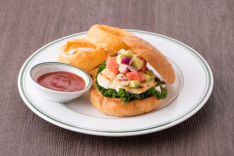 フィッシュバーガー 1,200円。直火焼きした白身魚、ケール、ざく切りトマトとアボカドで作ったサルサソース、ケールをトッピングしたあっさりテイストが魅力のヘルシーバーガー。ケチャップをベースに、ホースラディッシュを効かせたロシアンドレッシングが決め手。