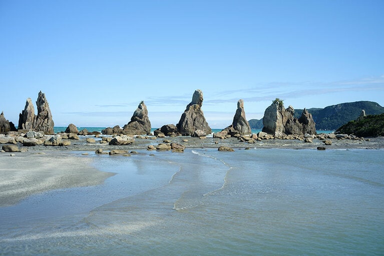 串本の人気観光スポット、橋杭岩。海の浸食により、あたかも橋の杭だけが立っているように見えることから名付けられた。その昔、弘法大師と天の邪鬼が賭をして、一夜にして立てたという伝説もあるという。