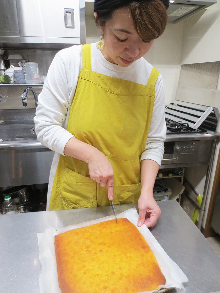 大きく焼いたレモンケーキをカットする吉野友佳子さん。