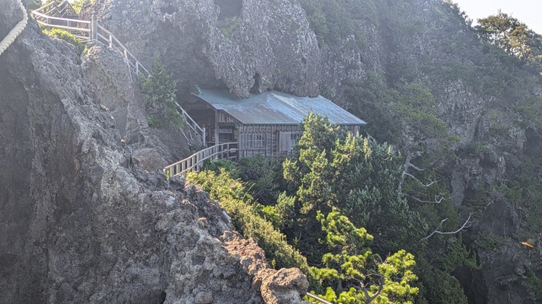 絶壁の窪みにはめ込むように建てられた石室（いろう）神社。