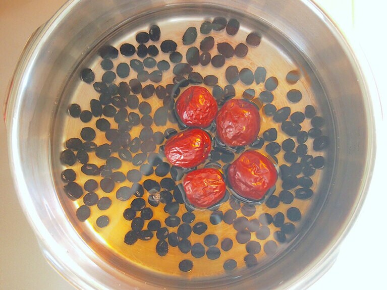 (1) 鍋に水、醤油、黒砂糖を入れて弱火で加熱します。砂糖が溶けたら火を止め、洗ったなつめと黒豆を入れます。蓋をしたまま、ひと晩吸水させます。