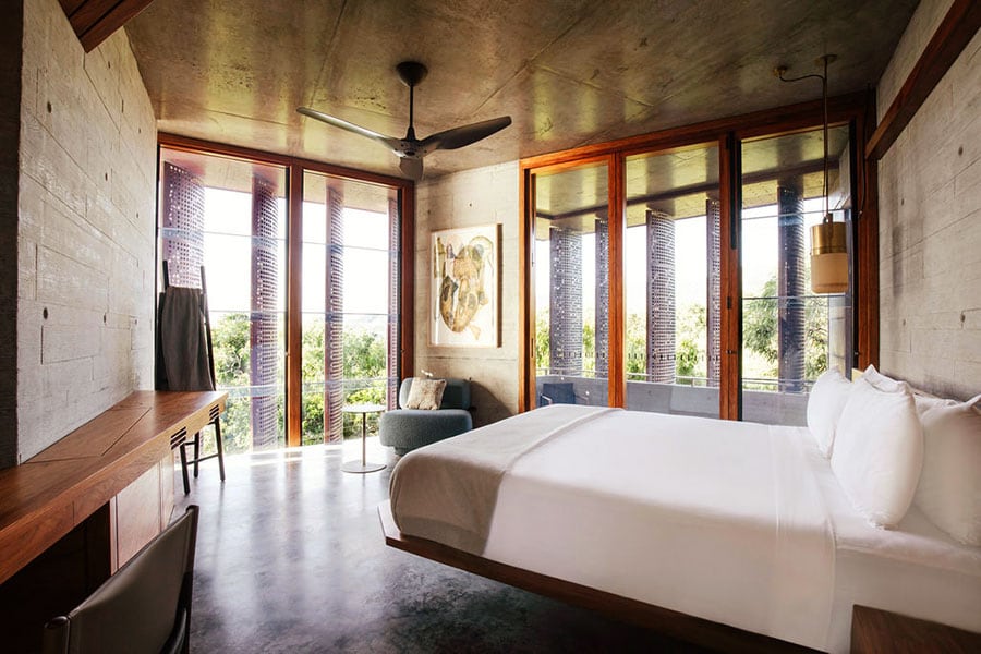 “ザ・ハウス”のベッドルームの一つ。ミニマルなインテリアで窓の外の自然が映える。