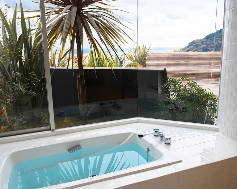 広々としたバスルームは海側がガラス張りで開放感いっぱい。