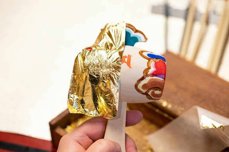 下絵に沿って1色ずつ色をのせ、にかわを溶かしたもので縁取りをして金箔をペタッ。