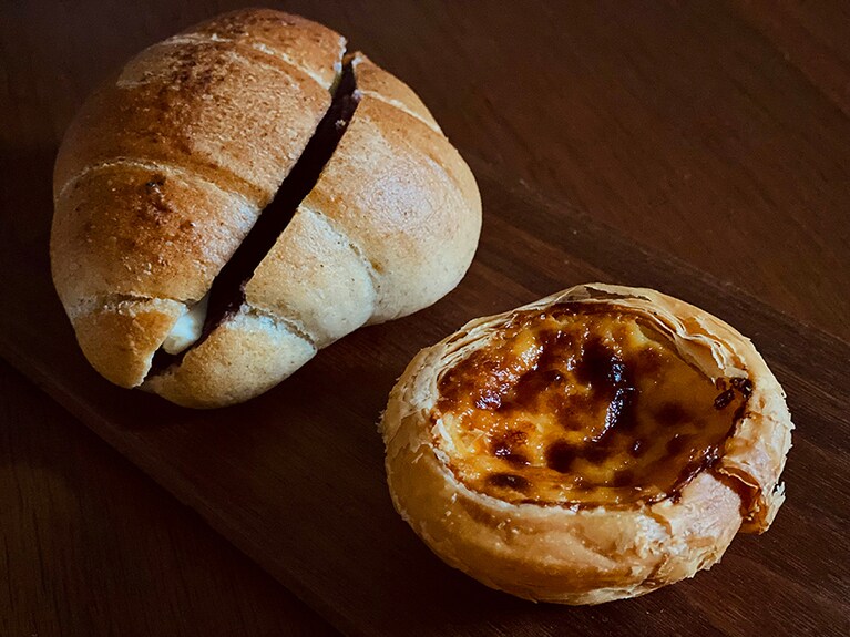 看板商品の「横濱エッグタルト」(220円)と「塩バターパンのあんバター」(319円)。